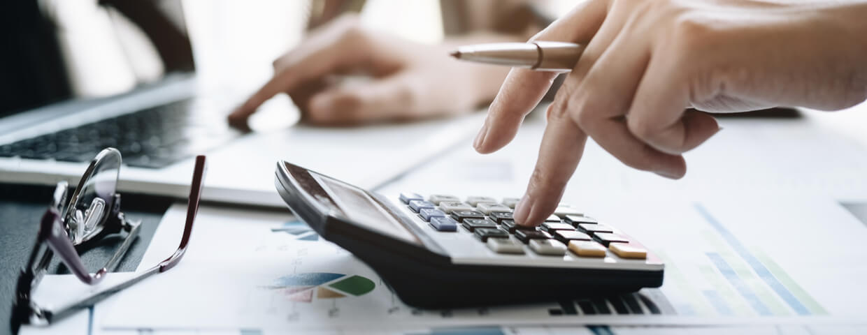 Businessman using calculator at office desk