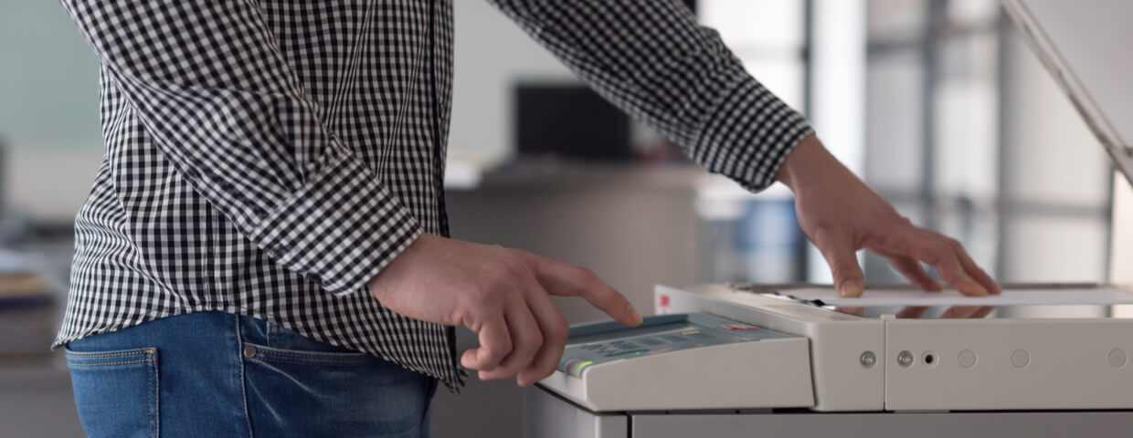 Man using multifunction scanner machine in office setting