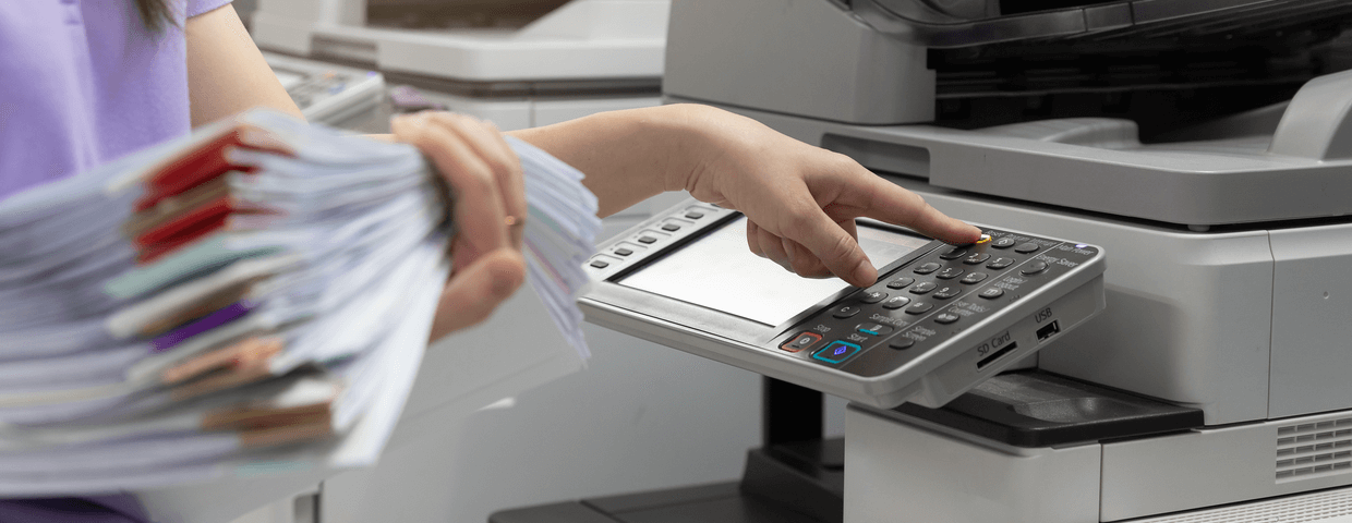 Woman scanning documents on office scanner.