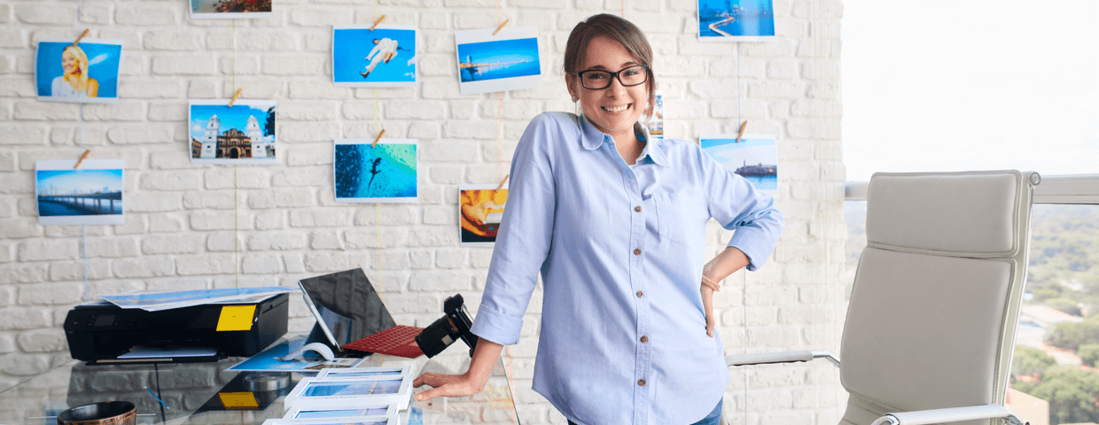 Small business owner, woman standing, smiling in office space.