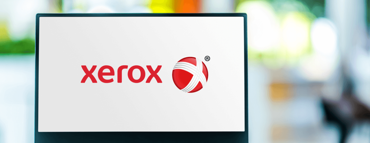 Laptop computer displaying logo of Xerox Holdings Corporation blurred background