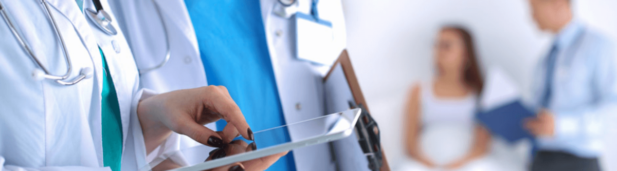 doctors and nurses in a hospital or healthcare office talking while looking at a tablet, digital documents